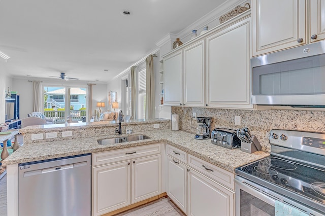 kitchen with appliances with stainless steel finishes, tasteful backsplash, sink, kitchen peninsula, and crown molding