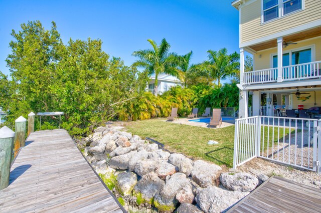 view of yard featuring a patio, a balcony, and ceiling fan