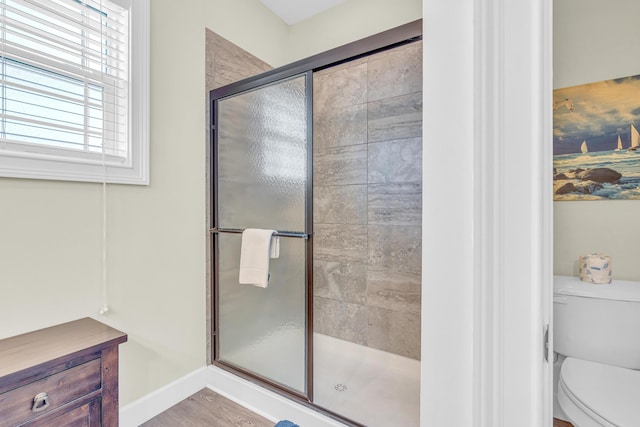 bathroom with a shower with door and toilet