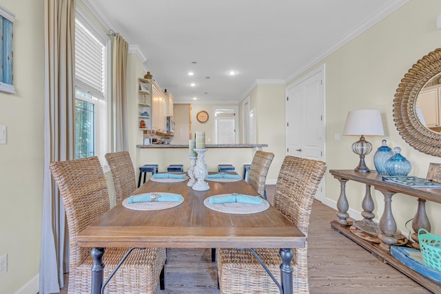 dining room featuring ornamental molding and light hardwood / wood-style flooring