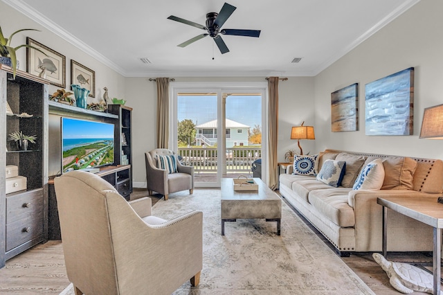 living room featuring crown molding, ceiling fan, and light hardwood / wood-style flooring