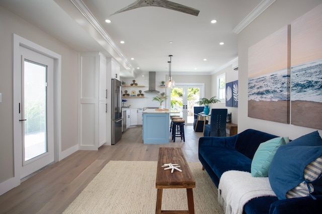 living room with ornamental molding, light hardwood / wood-style flooring, a wall mounted AC, and french doors