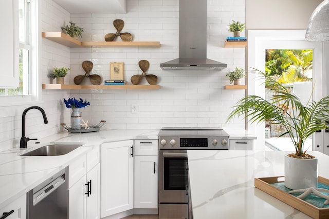 kitchen featuring sink, stainless steel range with electric stovetop, light stone counters, extractor fan, and white cabinets