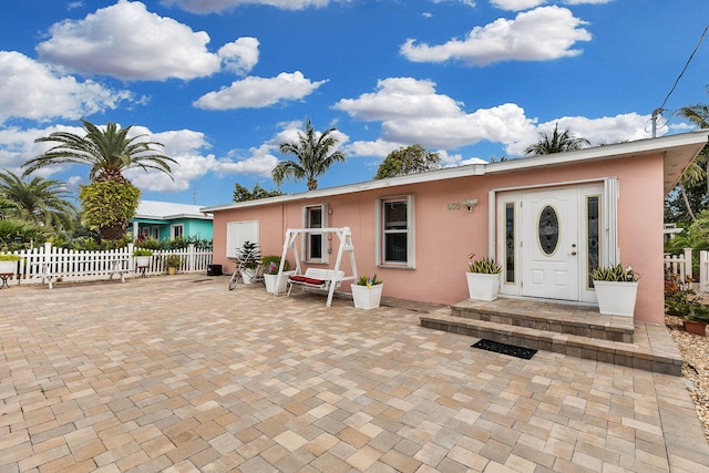 back of property with fence and stucco siding