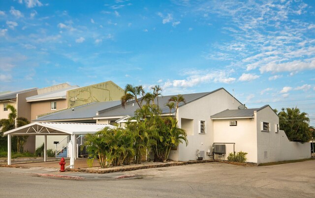 view of front of property featuring metal roof, central air condition unit, and stucco siding