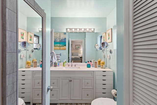 ensuite bathroom with a closet, vanity, toilet, and ensuite bathroom