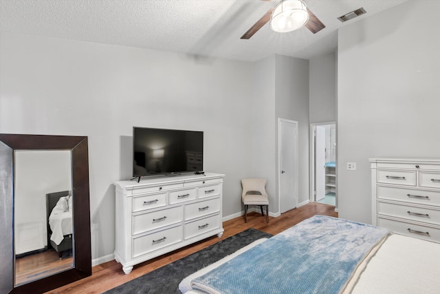 bedroom featuring visible vents, ceiling fan, baseboards, and wood finished floors