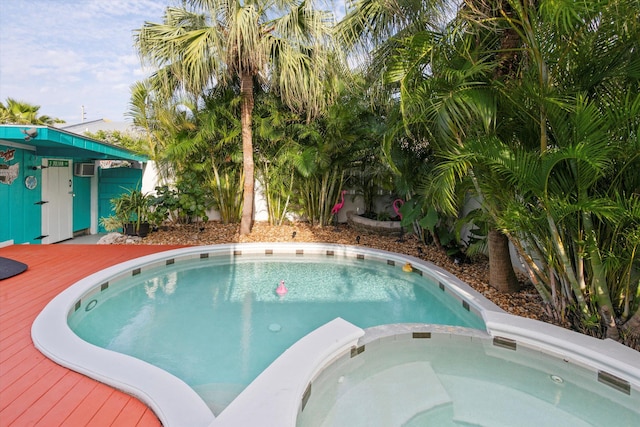 view of pool featuring a deck and a pool with connected hot tub