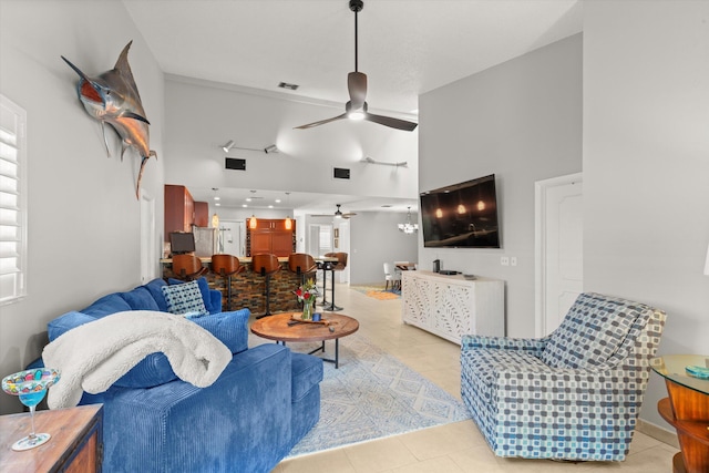 tiled living area featuring visible vents, baseboards, high vaulted ceiling, and ceiling fan