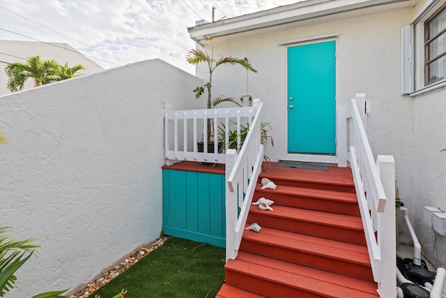 view of exterior entry featuring stucco siding