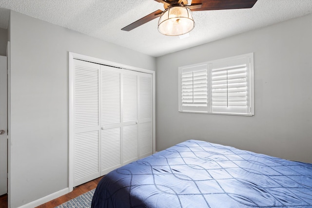 bedroom with ceiling fan, a closet, a textured ceiling, and wood finished floors