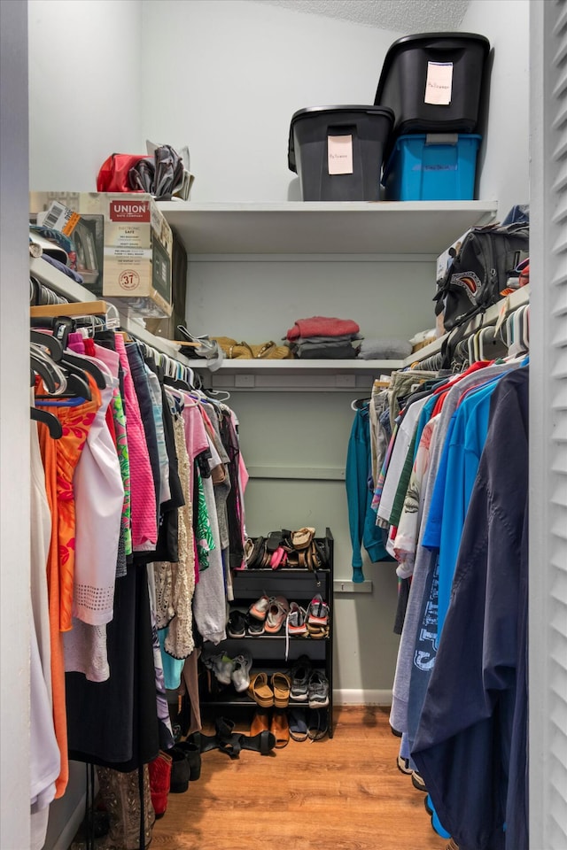 walk in closet with wood finished floors