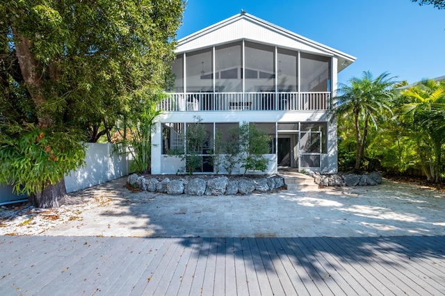 back of house with fence and a sunroom