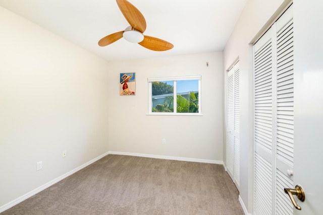 unfurnished bedroom featuring baseboards, carpet floors, a closet, and ceiling fan