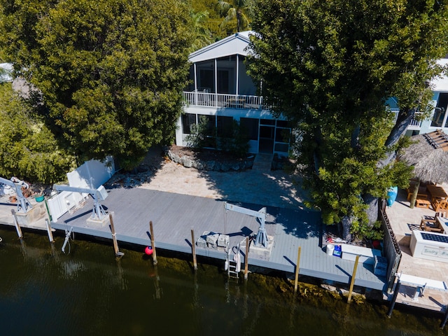 view of dock with fence, a water view, and boat lift