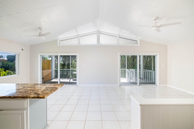 interior space with light tile patterned floors, baseboards, lofted ceiling, and a ceiling fan