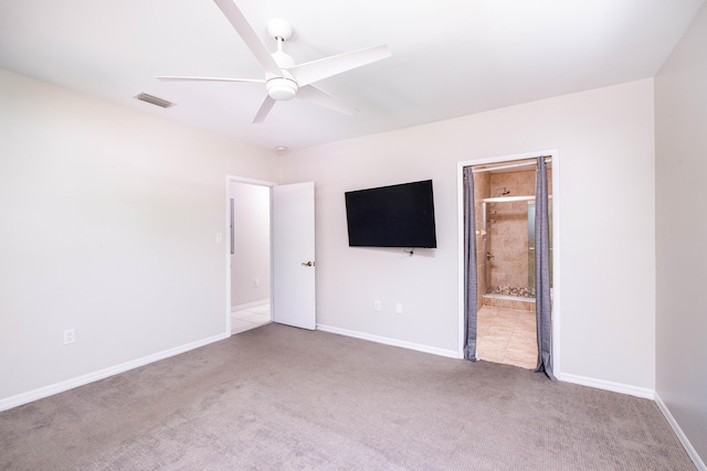 unfurnished bedroom featuring visible vents, baseboards, carpet, ensuite bath, and a ceiling fan