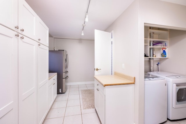 clothes washing area with track lighting, light tile patterned floors, and washing machine and clothes dryer