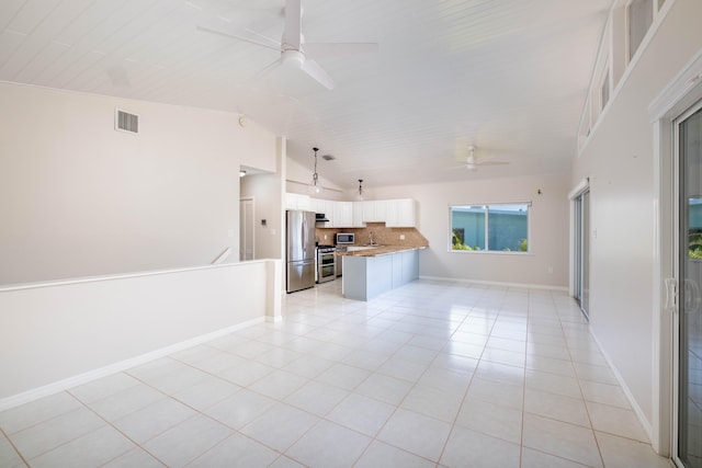 unfurnished living room with visible vents, light tile patterned floors, baseboards, ceiling fan, and vaulted ceiling