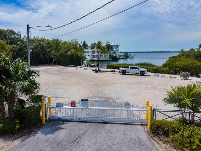 view of gate featuring fence and a water view