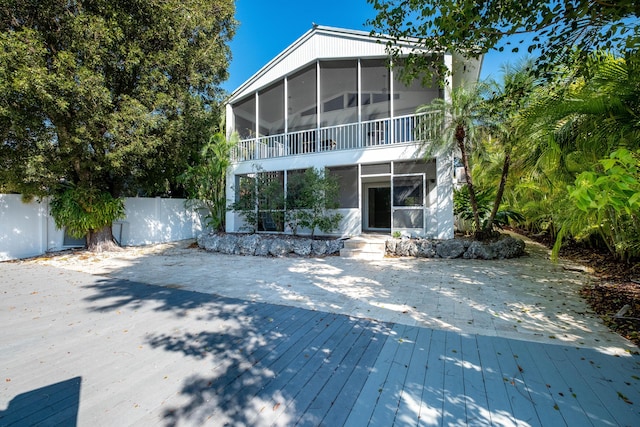 back of property featuring fence and a sunroom