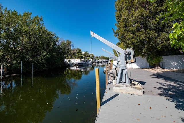 view of dock with a water view and fence