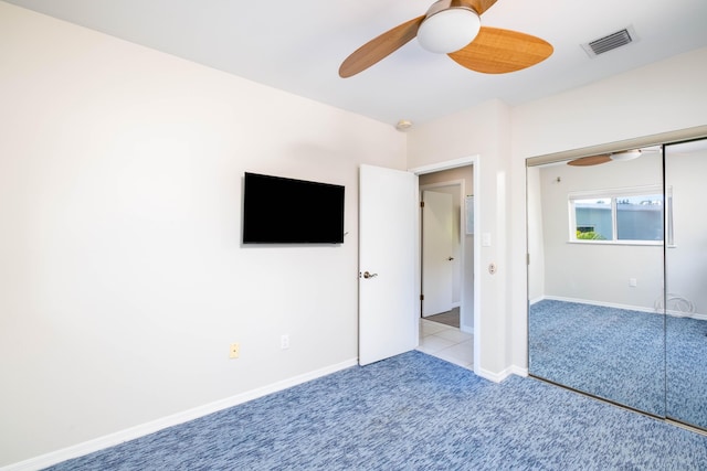 unfurnished bedroom with visible vents, baseboards, ceiling fan, carpet flooring, and a closet