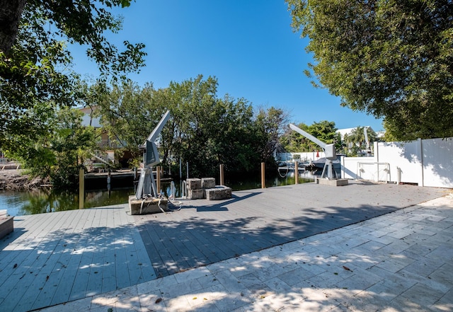 view of play area with a deck with water view and fence