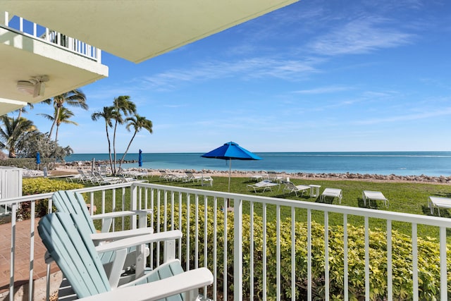 balcony with a water view and a view of the beach