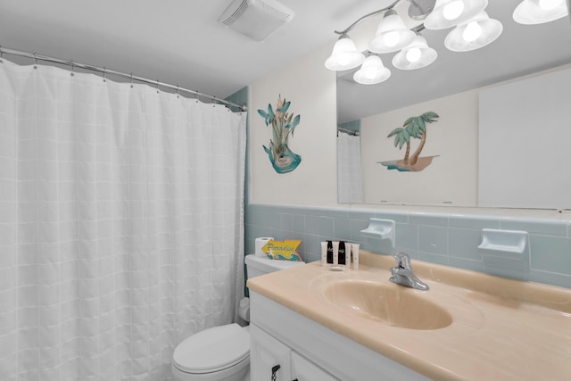 bathroom featuring vanity, tile walls, and toilet