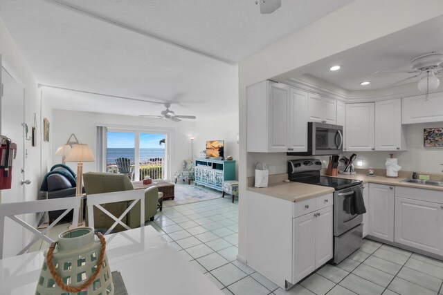 kitchen featuring white cabinetry, ceiling fan, appliances with stainless steel finishes, and light tile patterned floors