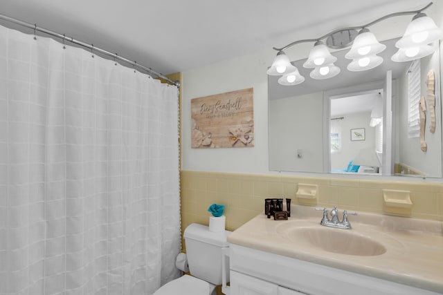 bathroom featuring tile walls, vanity, and toilet