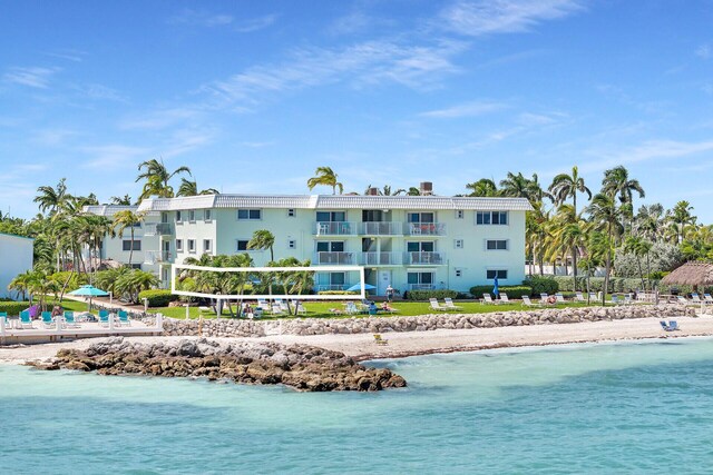 view of pool with a water view, volleyball court, and a beach view