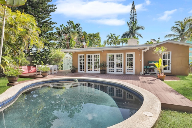 view of swimming pool with french doors and a deck