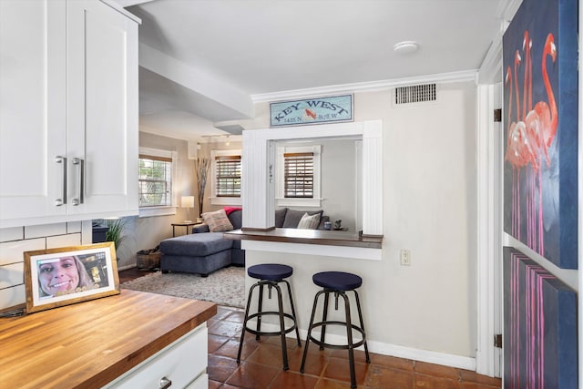 1116 Eaton St, Key West, FL 33040 - kitchen featuring a kitchen bar, white cabinetry, wood counters, and open floor plan