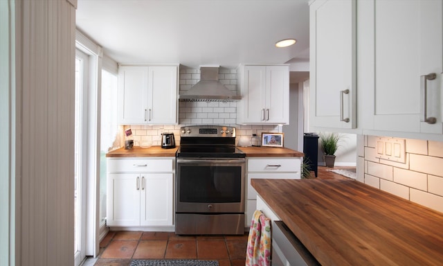 1116 Eaton St, Key West, FL 33040 - kitchen with butcher block countertops, stainless steel electric range oven, wall chimney range hood, backsplash, and white cabinets