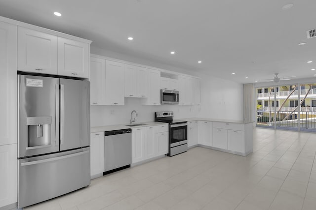 kitchen featuring recessed lighting, stainless steel appliances, a sink, white cabinetry, and light countertops