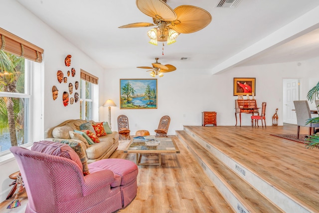 living room featuring a ceiling fan, visible vents, and wood finished floors