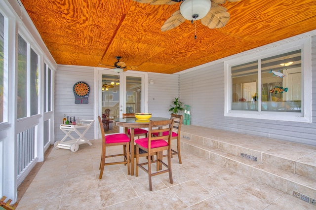 sunroom featuring ceiling fan and wood ceiling