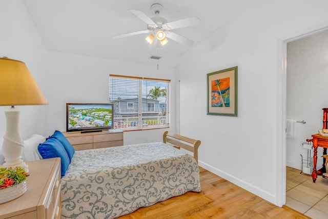 bedroom featuring ceiling fan, vaulted ceiling, and light wood-type flooring