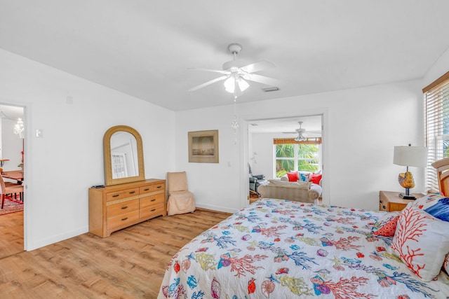 bedroom with ceiling fan, light wood-type flooring, visible vents, and baseboards