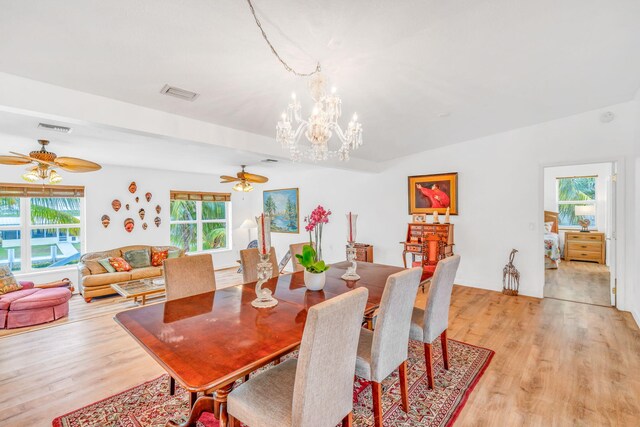 dining room featuring vaulted ceiling, light wood-style flooring, and visible vents