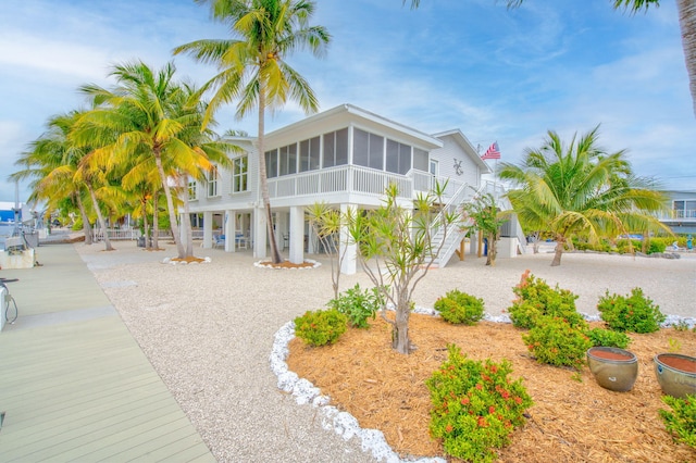 view of front of property with stairs and a sunroom