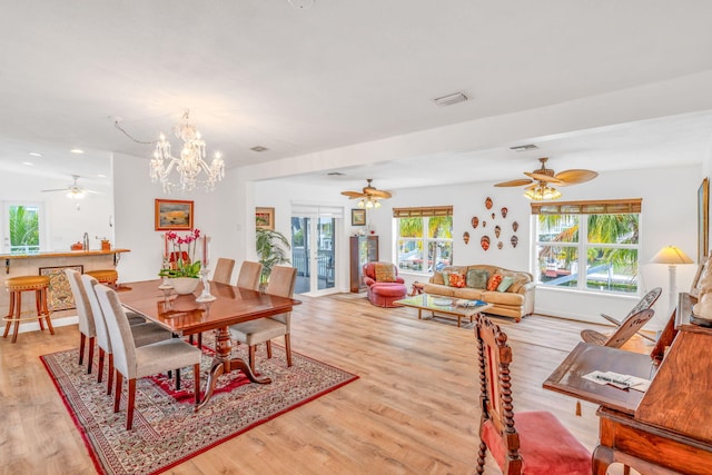 dining area with a wealth of natural light, a notable chandelier, and light wood-type flooring