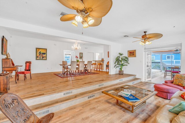 kitchen featuring sink, kitchen peninsula, wall chimney exhaust hood, and range with two ovens