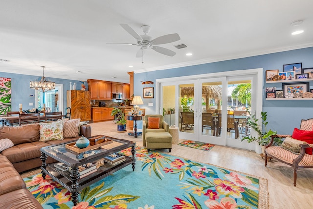 living room with french doors, ornamental molding, and ceiling fan with notable chandelier