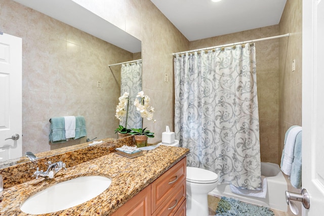 full bathroom featuring vanity, toilet, shower / tub combo, and tile walls