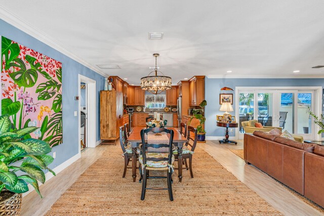 dining room with crown molding, an inviting chandelier, and french doors