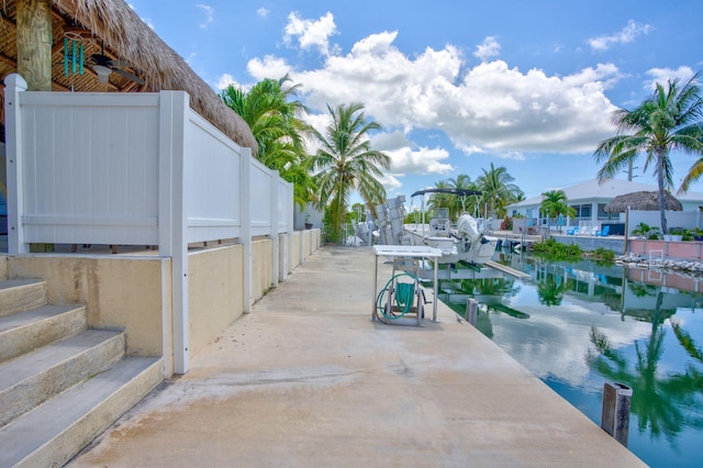 view of patio with a water view and a dock