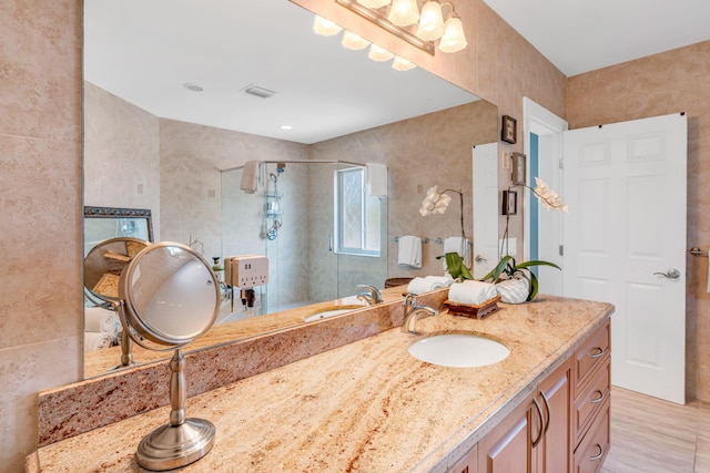 bathroom featuring vanity and a shower with door